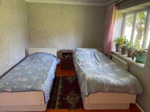 a bedroom with two beds and a window at magic home in Boz-Beshik