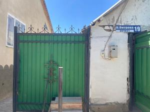 a green gate in front of a building at magic home in Boz-Beshik