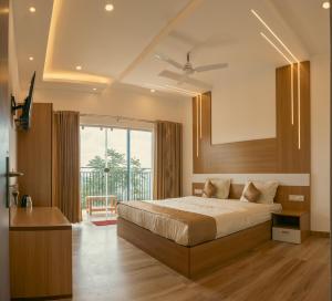 ein Schlafzimmer mit einem Bett und einem großen Fenster in der Unterkunft Udaya Hills Cottages in Vagamon