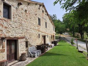 a building with a yard with benches and a rope at LA CEGNA in Montemaggio