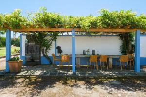 een tafel en stoelen onder een pergola bij Quinta Morazes Casas de Campo in Ribeira Grande