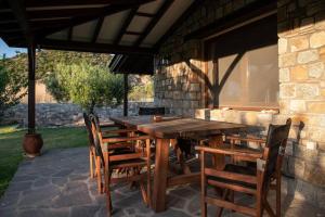 a wooden table and chairs on a patio at Olive Garden Toroni in Toroni