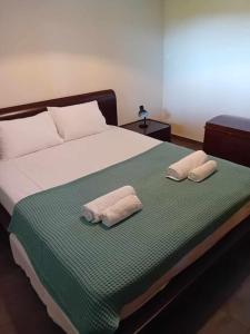 a bedroom with a bed with two towels on it at Olive Garden Toroni in Toroni