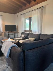 a living room with a couch and a tv at Olive Garden Toroni in Toroni