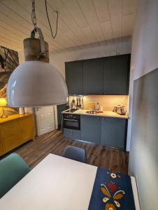 a kitchen with a table and a large light fixture at Wilhelms Kojen - Backbordkoje in Wilhelmshaven
