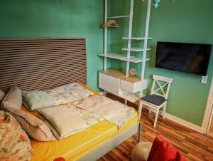 a bedroom with a bed and a tv and a chair at Wilhelms Kojen - Backbordkoje in Wilhelmshaven