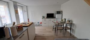 une cuisine avec une table et des chaises dans une pièce dans l'établissement Maison de bourg, à Jumeaux