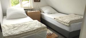 une chambre avec deux lits et une fenêtre dans l'établissement Haus am Schlei Noor, à Maasholm