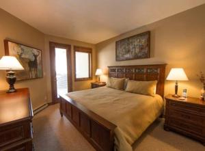 a bedroom with a large bed with two tables and two lamps at Strawberry Park Luxurious Condos Directly on the Slopes Next to Chairlift condo in Beaver Creek
