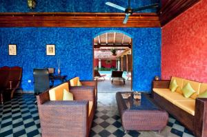 a living room with blue walls and a couch and chairs at Hotel Casa del Consulado in Granada