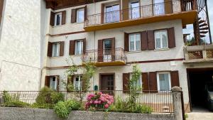 a building with balconies and flowers in front of it at villa Ada apartment in Cercivento