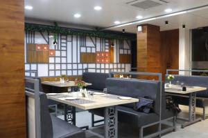 a dining room with tables and chairs in a restaurant at Hotel Lémore Stay & Dine in Solapur