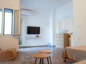 a room with two stools and a bed and a tv at Sophellie's place Skiathos in Skiathos