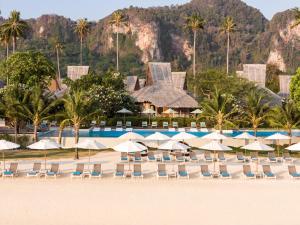 a beach with chairs and umbrellas and a resort at SAii Phi Phi Island Village in Phi Phi Islands