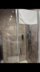 una doccia in un bagno con una porta in vetro di Apartament Morski Widok a Jarosławiec Altre 3 foto