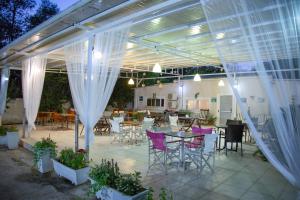 un patio con tende bianche, tavoli e sedie di Villa Pap a Preveza