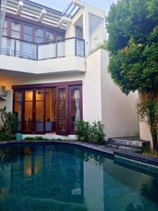 a house with a swimming pool in front of it at Dana Villa Bali in Seminyak