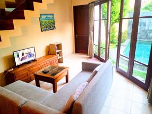 a living room with a couch and a table at Dana Villa Bali in Seminyak