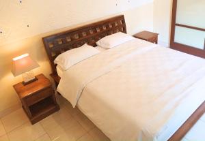 a bedroom with a bed and a lamp on a table at Dana Villa Bali in Seminyak