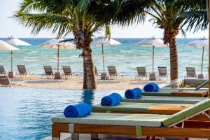 a row of lounge chairs and umbrellas on the beach at SAii Phi Phi Island Village in Phi Phi Islands