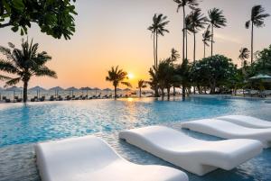 a swimming pool with two white chairs in a resort at SAii Phi Phi Island Village in Phi Phi Islands
