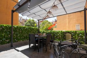 a table and chairs under an umbrella on a patio at Vatican Boutique Apartment with large Terrace in Rome