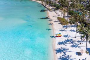 an aerial view of a beach with palm trees and boats at SAii Phi Phi Island Village in Phi Phi Islands