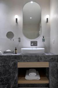 a bathroom with a sink and a mirror at Princess Resort, Santikos Collection in Agia Paraskevi