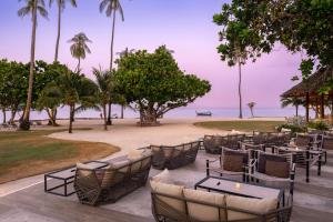 a restaurant with tables and chairs on the beach at SAii Phi Phi Island Village in Phi Phi Islands