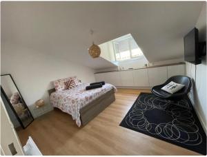 a bedroom with a bed and a chair in it at Grand Appartement Hypercentre avec Terrasse et Parking in Poitiers