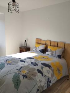 Un dormitorio con una cama con un edredón floral. en La Ferme d'Adèle, en Tence