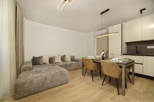 a living room with a couch and a table with chairs at Villa BILA - Apartment Mari in Podstrana