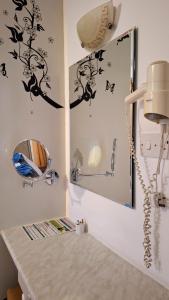 a bathroom with a mirror and a sink at Apollonia Hotel Apartments in Paphos City