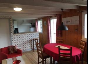 PlougoulmGîte Sieck Moulin de Kerellec的有红色桌子和椅子的餐厅