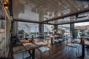 a restaurant with tables and chairs and large windows at Pansion Kamenar 2 in Primošten