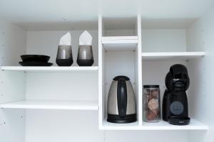 a white cupboard with black appliances in it at Silver Moon Residence 1 in Arad