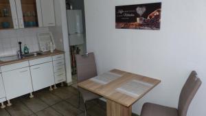 a kitchen with a wooden table and a sink and a counter at Haus am Bahndamm in Holzminden +6 photos