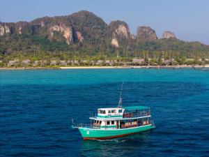 a green and white boat in the water at SAii Phi Phi Island Village in Phi Phi Islands