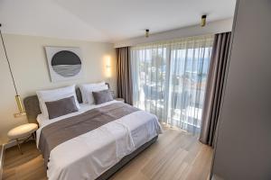 a bedroom with a large bed and a large window at Exlusive Villa M -Baska Voda in Baška Voda +124 photos