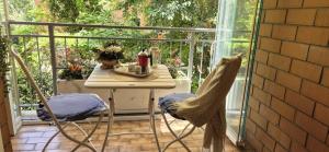 a table and two chairs on a balcony with a table and a window at EUR Fenix Apartment free parking family in Rome