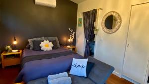 une chambre avec un lit, un canapé et un miroir dans l'établissement The Nature Resort Villas Ramada Resort, à Cowes