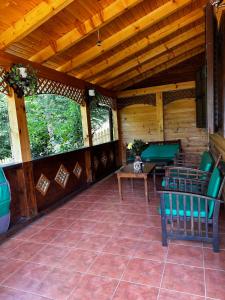 a screened in porch with green chairs and a table at Panoramic Apart Lepsa in Lepşa