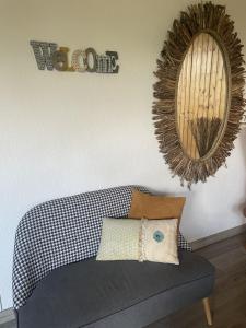 a living room with a couch and a mirror at Le Domaine de la Caille - L'Hôtel in La Balme-de-Sillingy