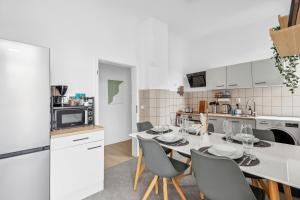 a kitchen with a table and chairs in a kitchen at FABYLOUS Homes City Apartment I Gruppen I Waschtrockner I Balkon I belebte Lage in Wiesbaden