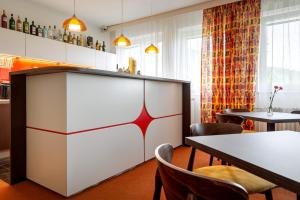 a restaurant with a counter and chairs and tables at Retro Hotel JISKRA in Čeladná