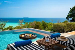 a swimming pool with two lounge chairs and a fire pit at SAii Phi Phi Island Village in Phi Phi Islands