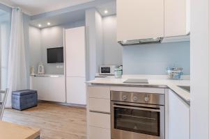 a kitchen with white cabinets and a stove top oven at H11 CASA CAMILLA Centro - Sanremo in Sanremo