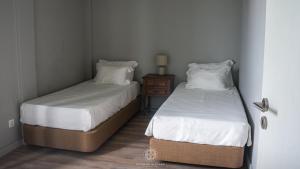 zwei Betten in einem kleinen Zimmer mit einem Nachttisch und zwei Betten sidx sidx sidx in der Unterkunft MainStreet, VintageGroup in Espinho
