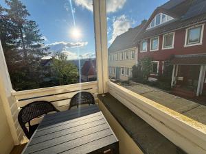 a porch with a bench and a window with the sun at Ferienwohnung Daisy in Sankt Andreasberg