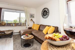 ein Wohnzimmer mit einem Sofa und einer Obstschale auf einem Tisch in der Unterkunft FeWo Harzer Leidenschaft bis 2 Hunde Willkommen TOP Lage DTV 5 Sterne 3 Pfoten in Sankt Andreasberg